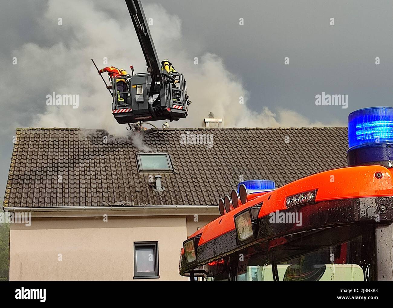 Karlsruhe, Germany. 07th June, 2022. Firefighters extinguish a fire in a roof truss. A lightning strike during a thunderstorm triggered a fire in the roof of a single-family house in Karlsruhe - and caused extensive damage. A neighbor noticed smoke on the roof of the house in the Rintheim district on Tuesday evening and notified the residents, who then left the building, the police said in the evening. Credit: Thomas Riedel/dpa/Alamy Live News Stock Photo