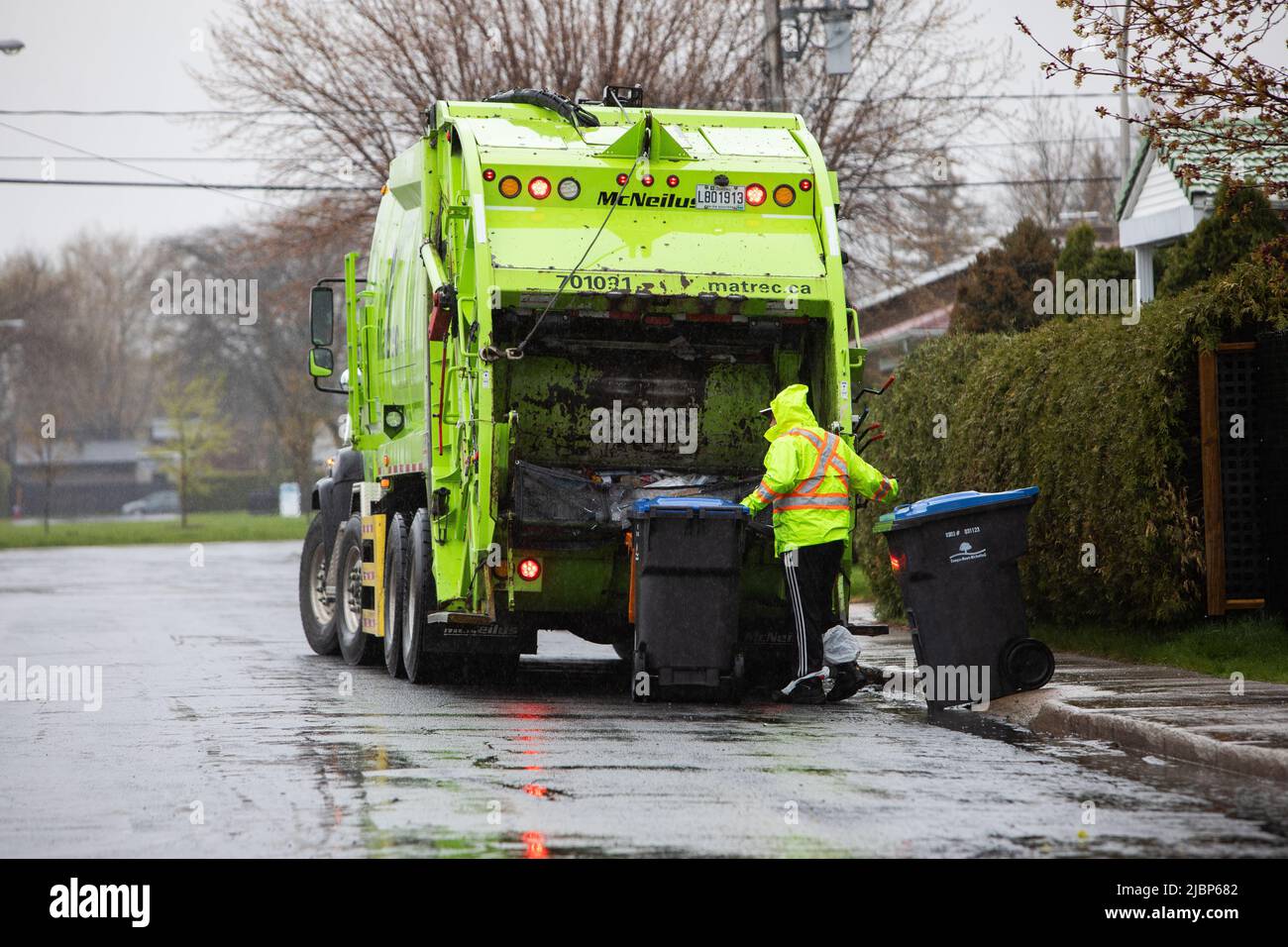 recycle bin on the street getting picked up by the recycle truck