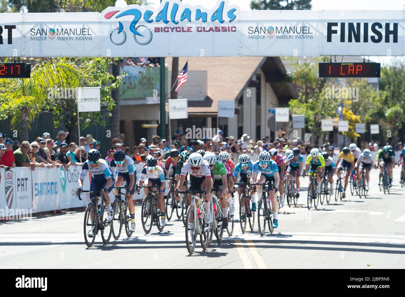 Women's peloton racing during the Redlands Classic Criterium in downtown Redlands, CA Stock Photo