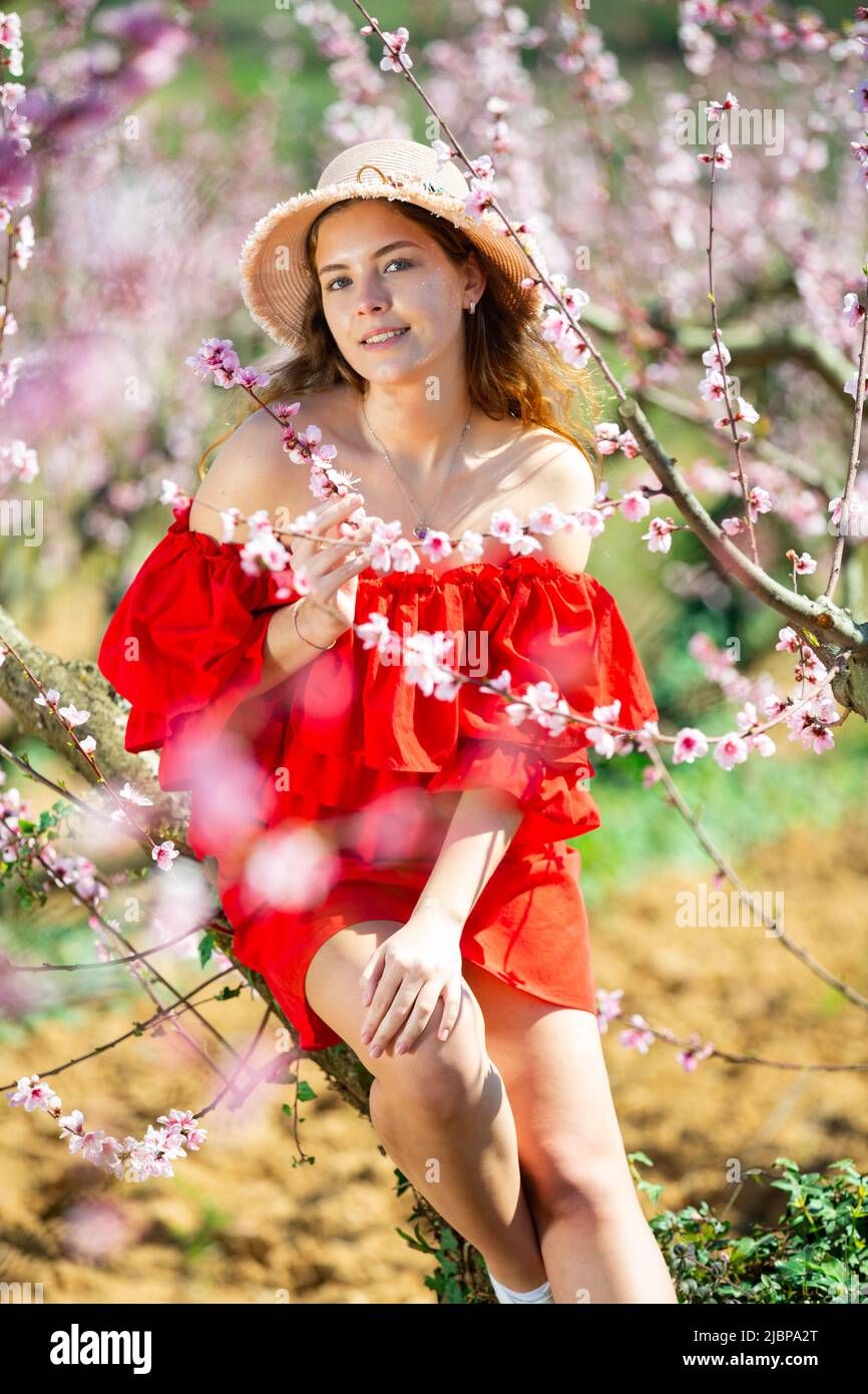 Cheerful girl posing in a red dress in spring blooming garde Stock ...