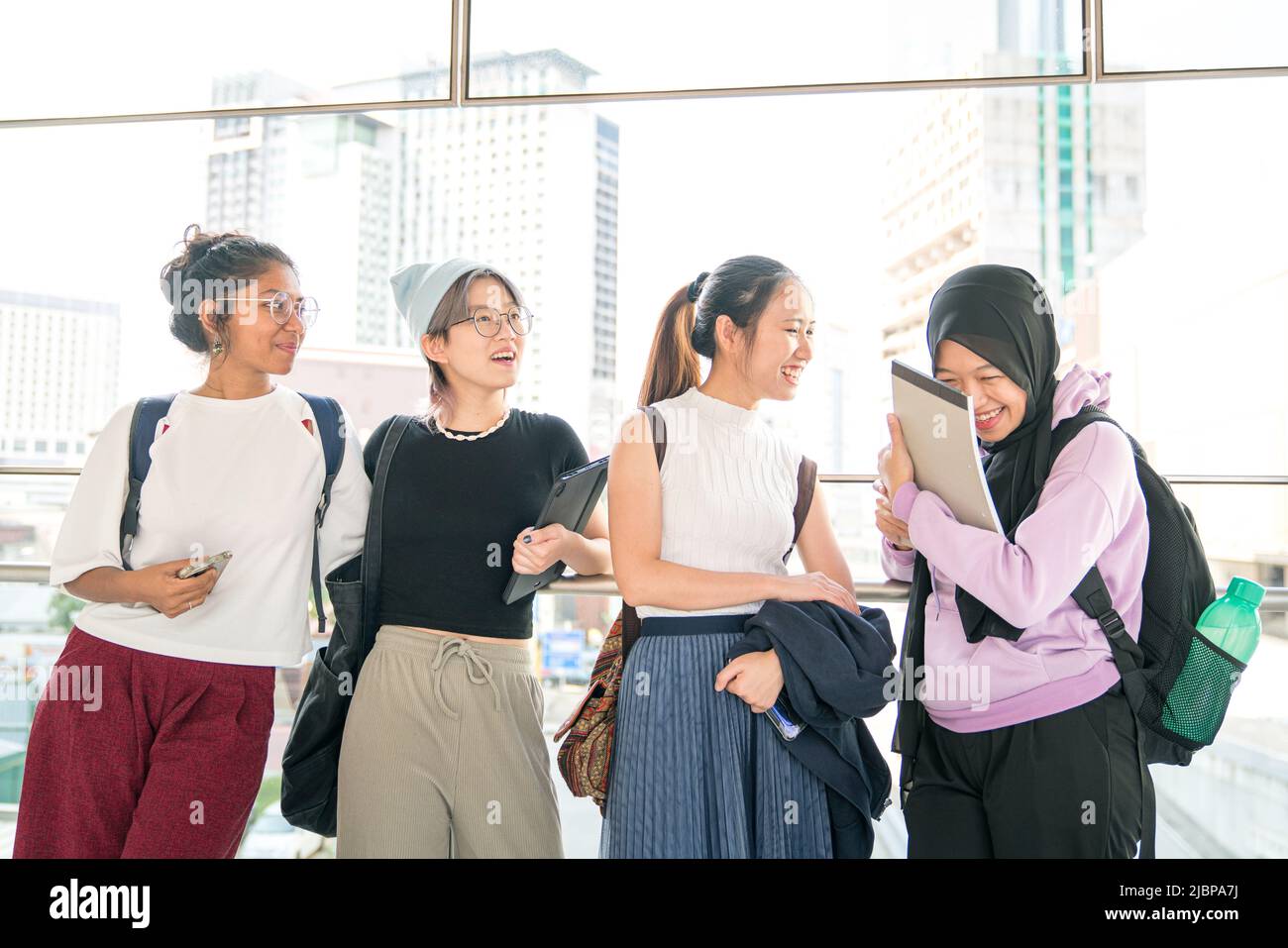 Four multi-racial young women students laughing. Celebrating friendship concept. Stock Photo