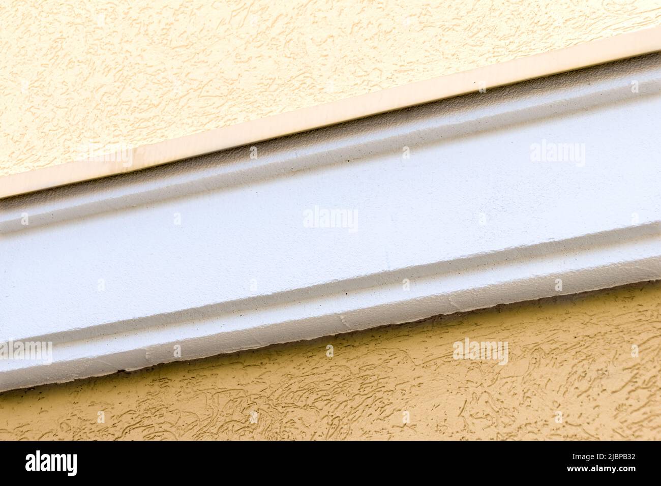 polystyrene border closes the expansion joint on the facade, waterproofing joint between the foundation and the wall, selective focus Stock Photo