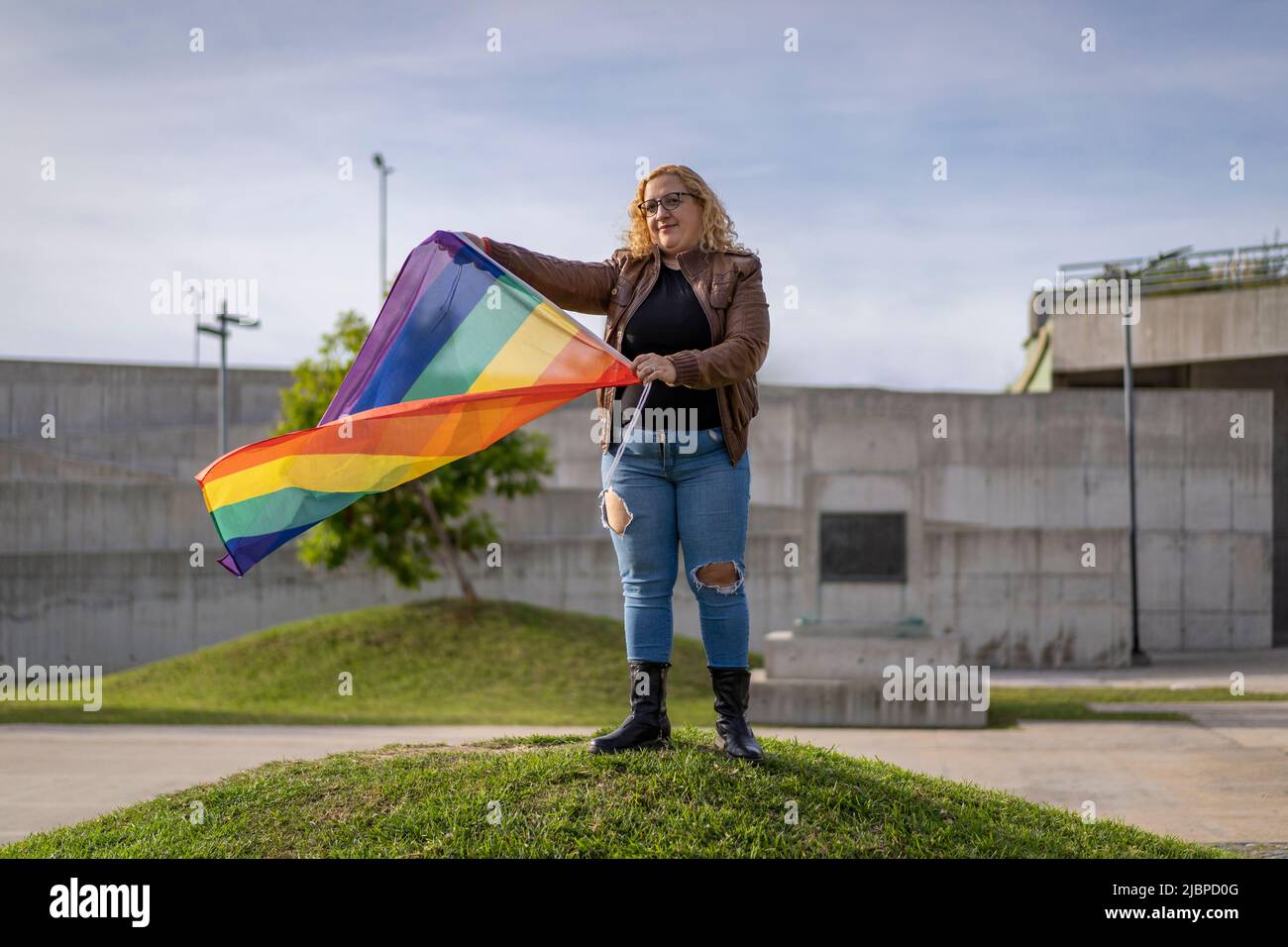 Young blonde woman holding lgbt flag. Concept of freedom and tolerance Stock Photo