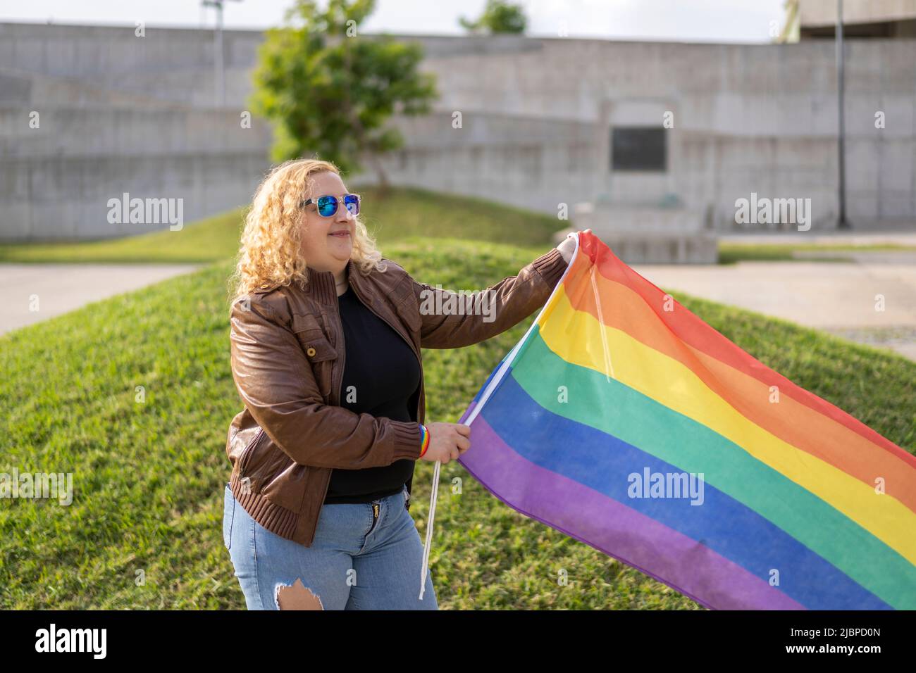 Young blonde woman holding lgbt flag. Concept of freedom and tolerance Stock Photo