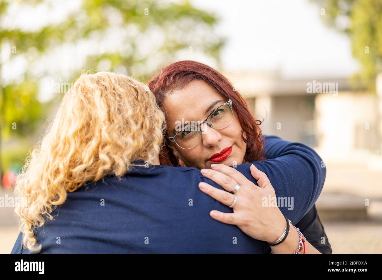 Couple of lesbian women hugging in a park Stock Photo