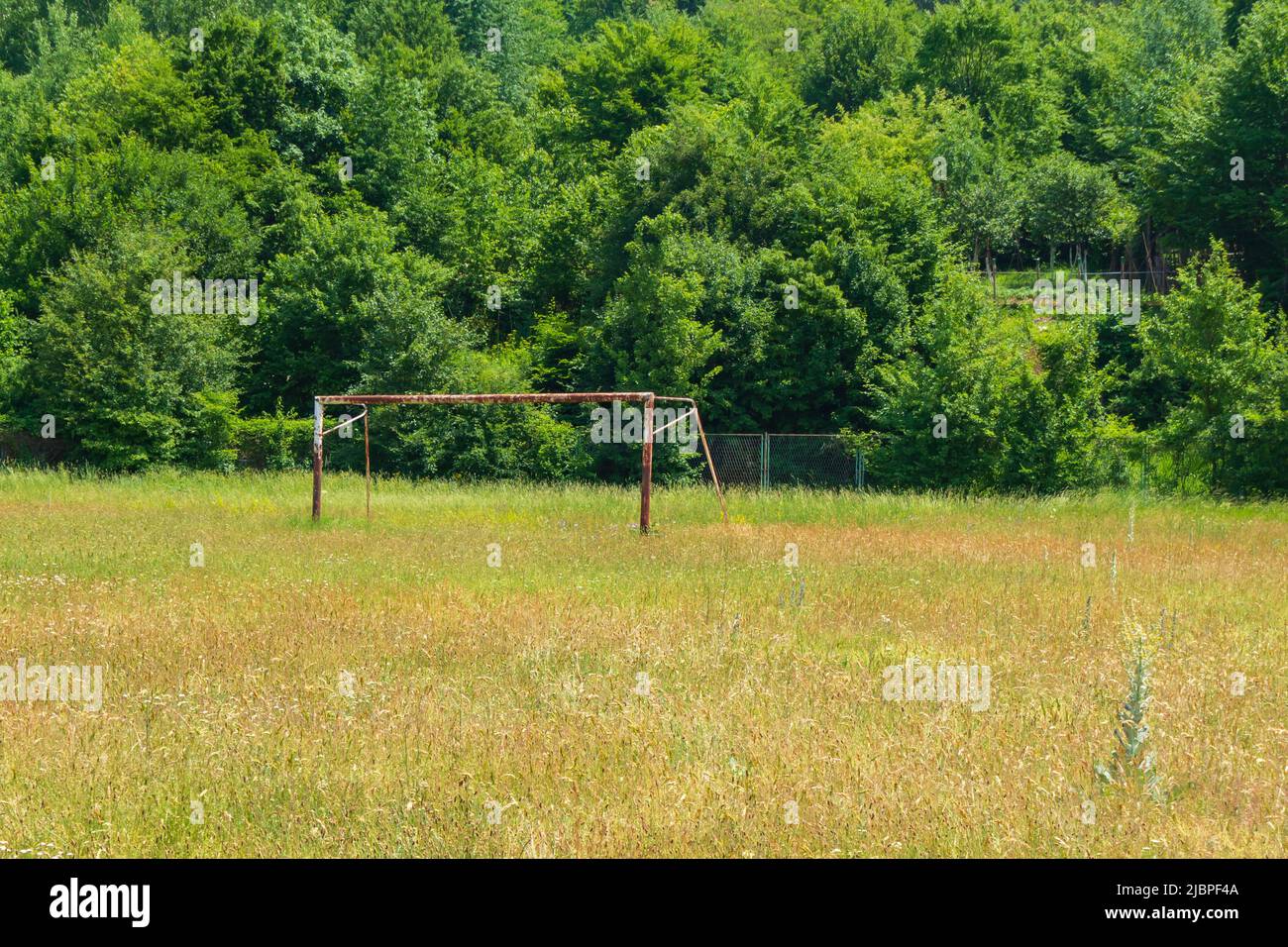 Abandoned pitch with rusty goals. Consequence of the white plague. Stock Photo