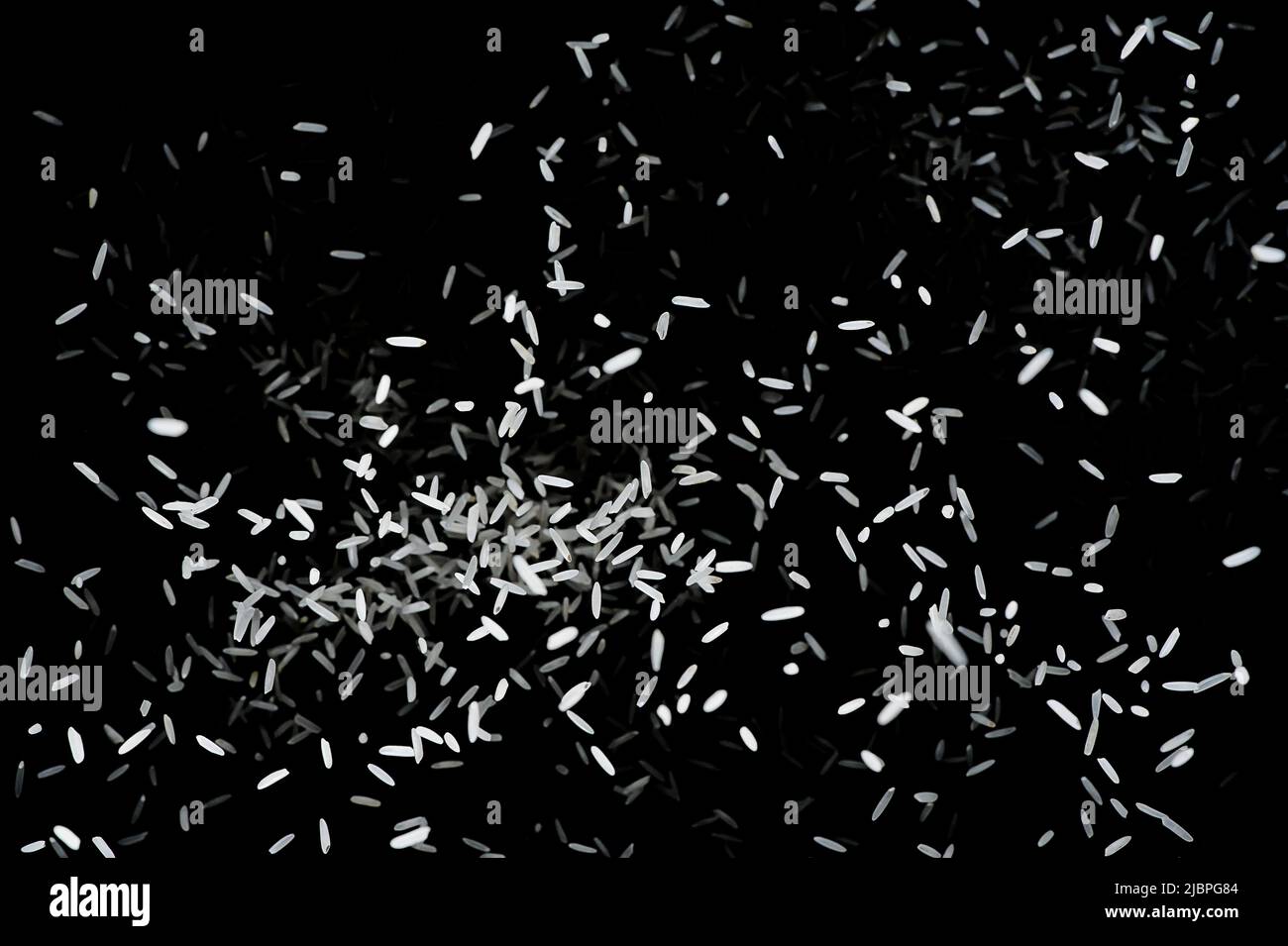 Heap of raw rice on dark background. Raw white rice explosion. faling ...