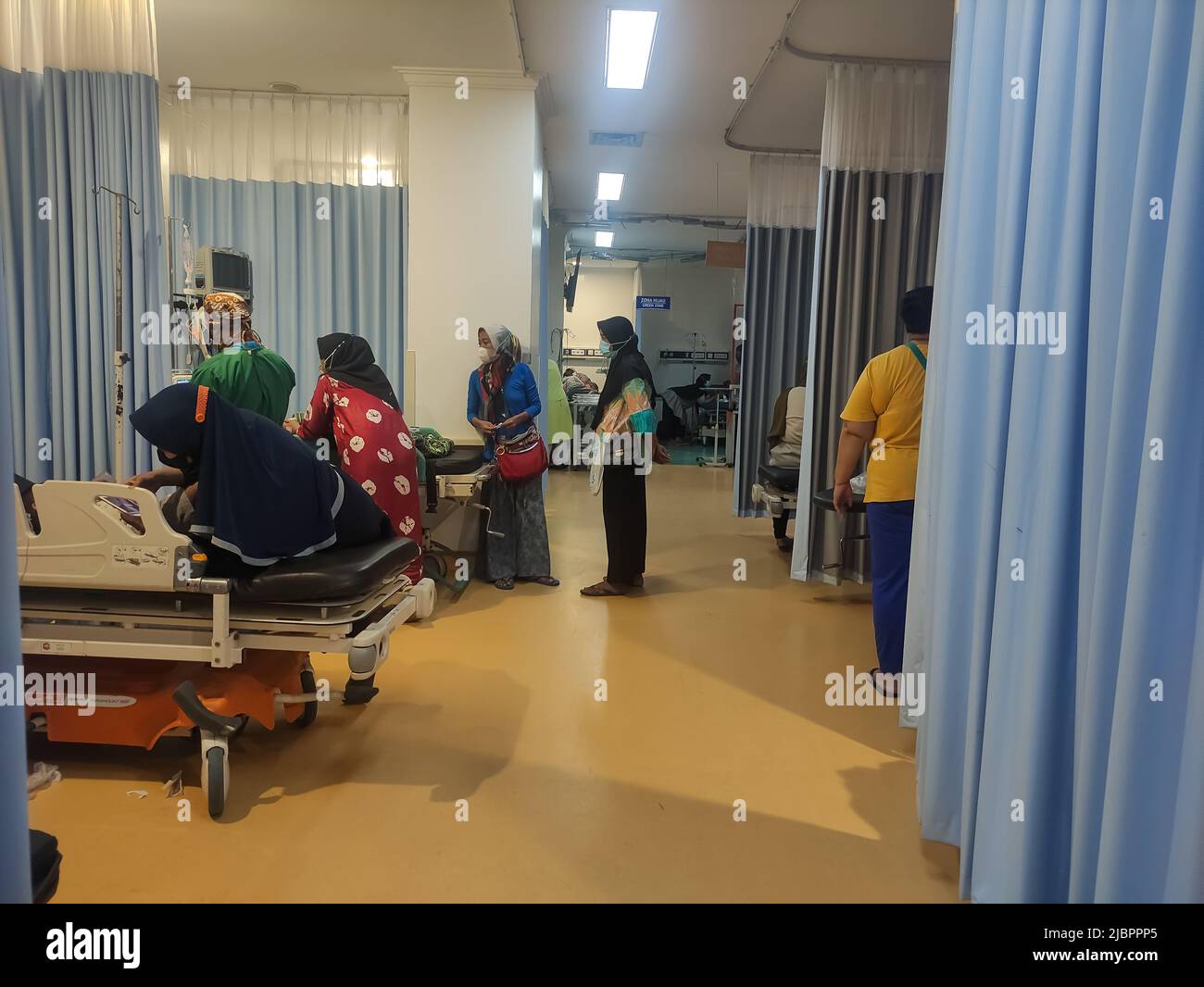 atmosphere in the emergency room at the hospital.  the patient is being examined by a doctor and accompanied by his family Stock Photo