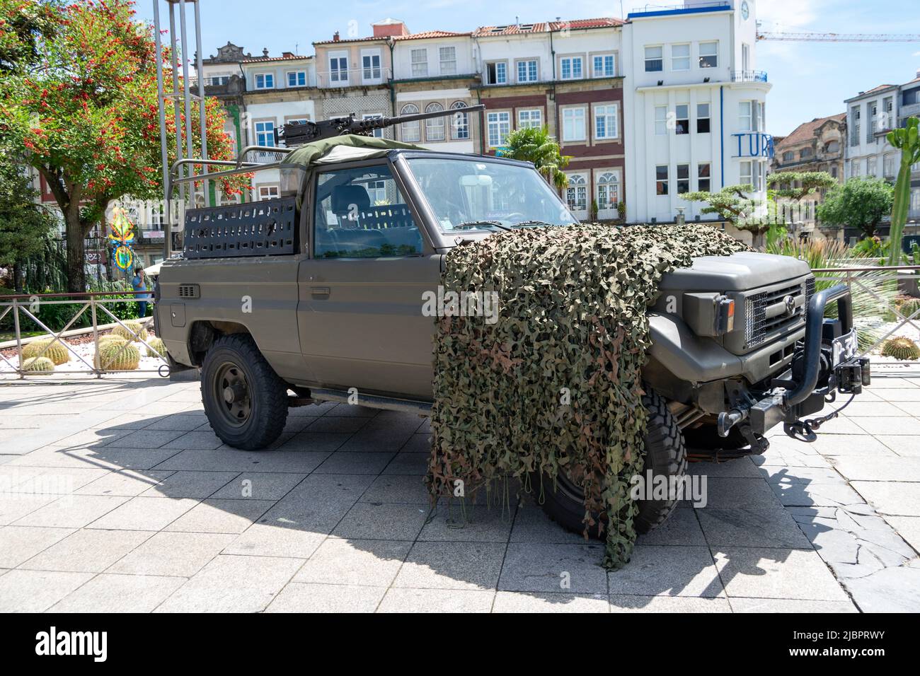 Armed military vehicles with camouflage on urban áreas heavy crowded with civilians. Portugal 10 June commemorations in the city of Braga. Stock Photo
