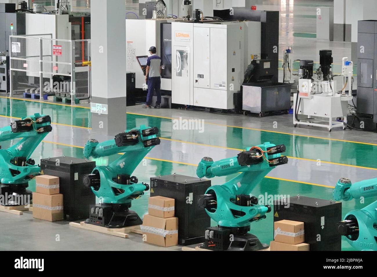 YANTAI, CHINA - JUNE 8, 2022 - A worker operates an intelligent machine tool to make an industrial robot at Aidi Precision Machinery Co., LTD in Yanta Stock Photo