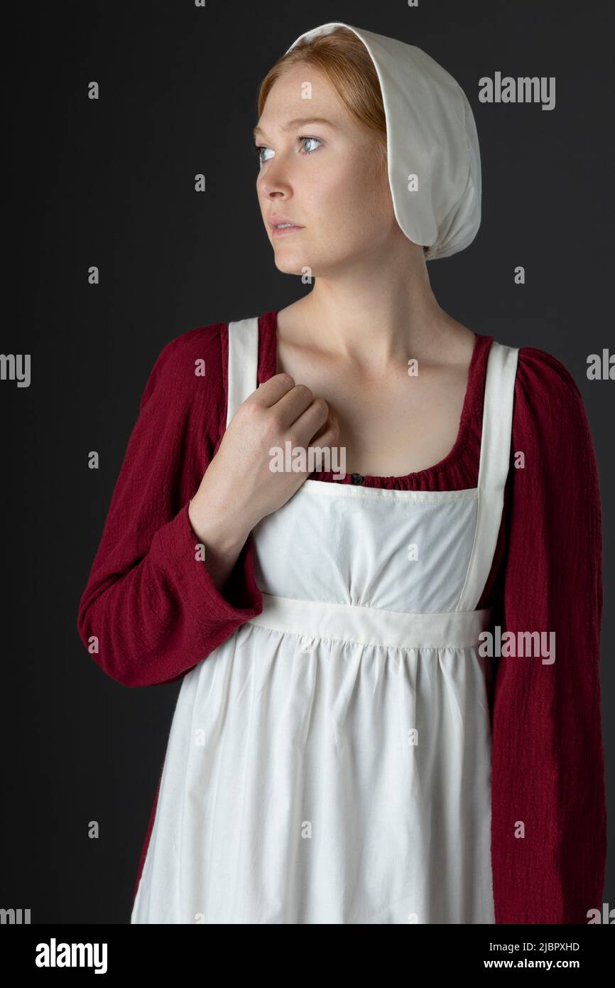 A Regency serving maid wearing a red dress and an apron Stock Photo