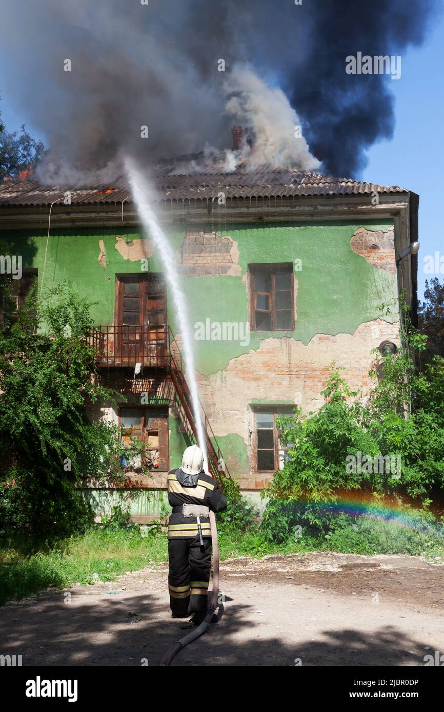 Firefighter extinguish a fire in an abandoned house with a hydrant ...