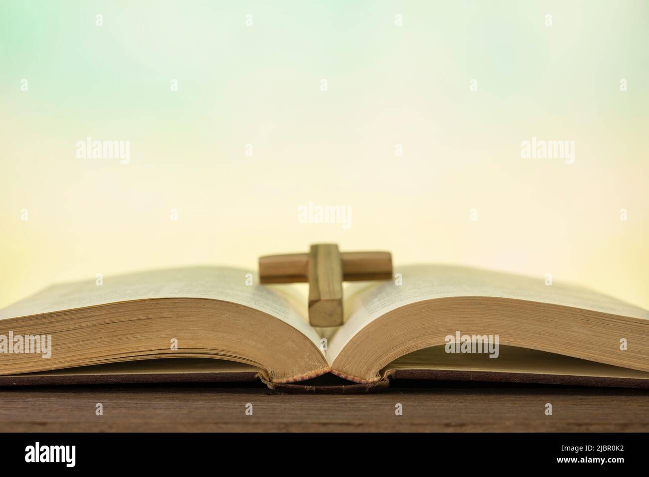 Open bible book on wood table with abstract light background. Stock Photo