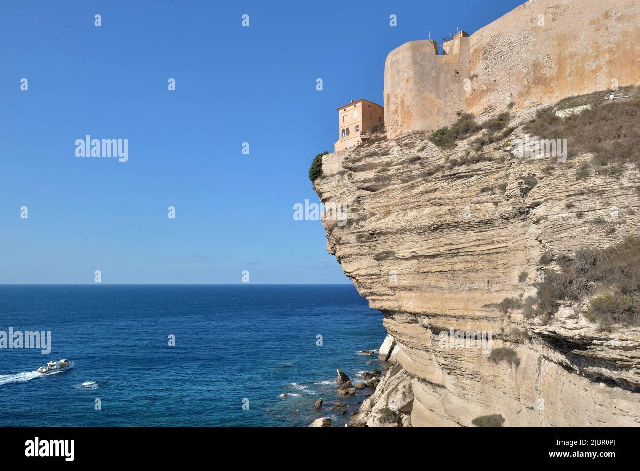 rampart above limestone cliff fo city Bonifacio in Corsica overlooking the sea on clear blue sky Stock Photo