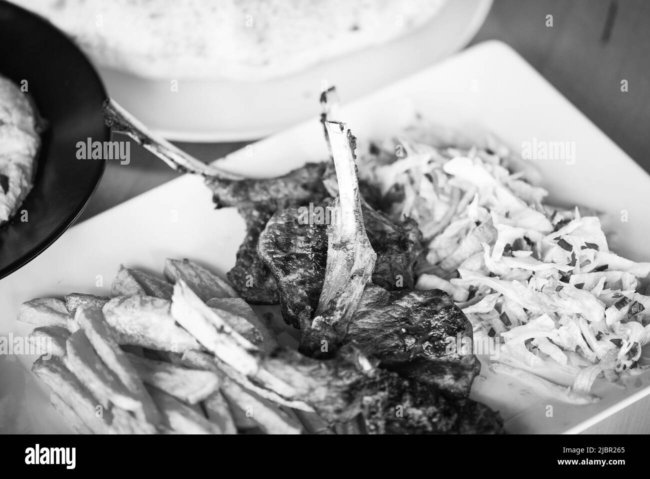 delicious grilled lamb chopsticks with french fries, pesto sauce & mix of lettuces Stock Photo