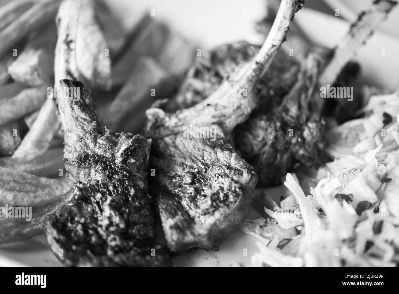 delicious grilled lamb chopsticks with french fries, pesto sauce & mix of lettuces Stock Photo