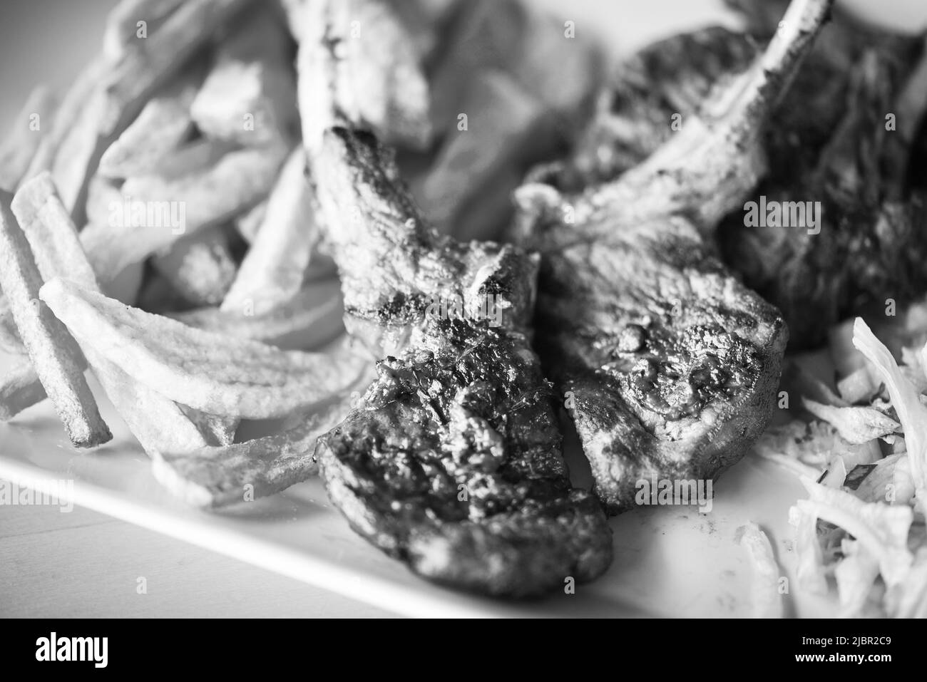 delicious grilled lamb chopsticks with french fries, pesto sauce & mix of lettuces Stock Photo