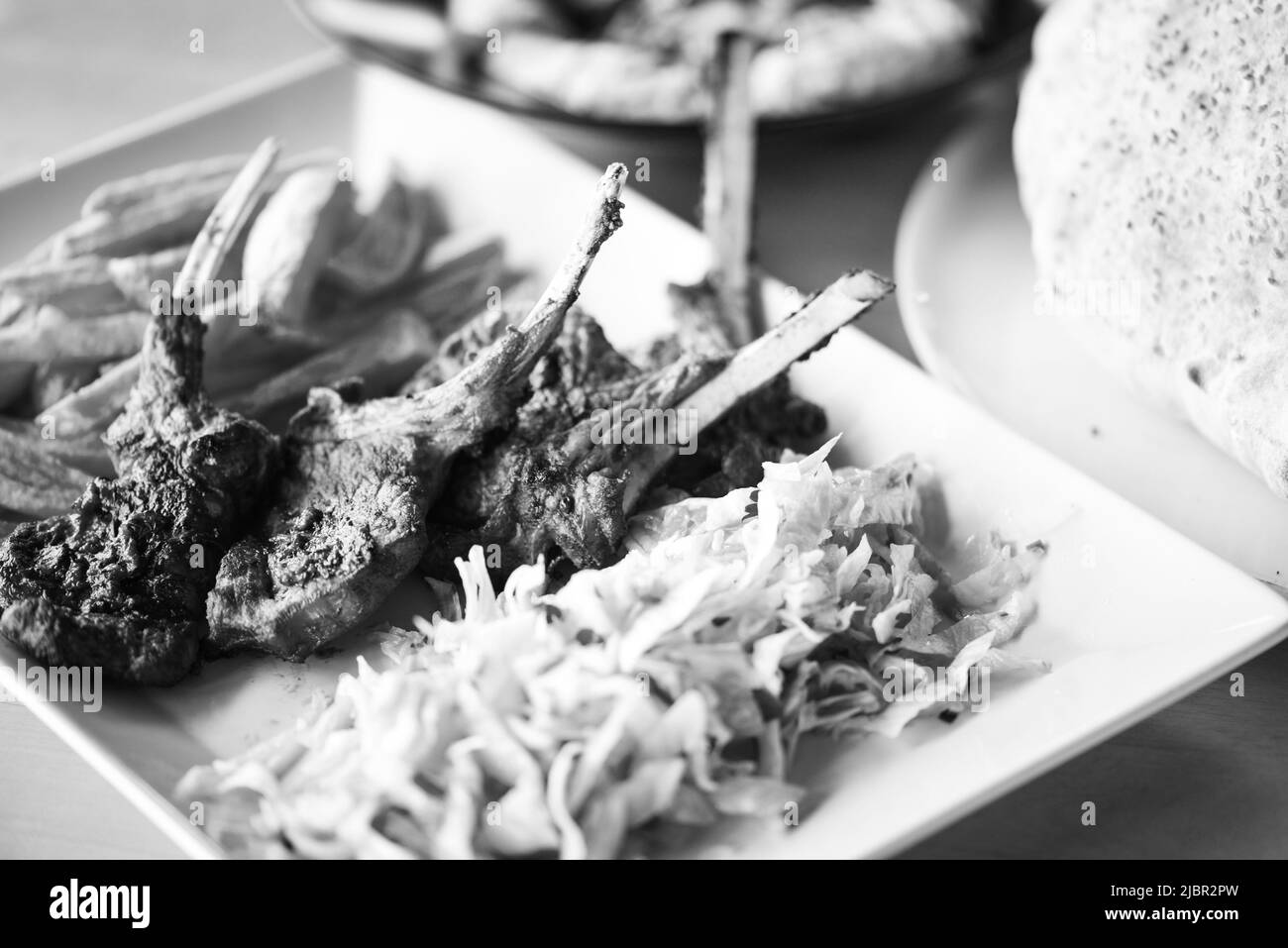 delicious grilled lamb chopsticks with french fries, pesto sauce & mix of lettuces Stock Photo