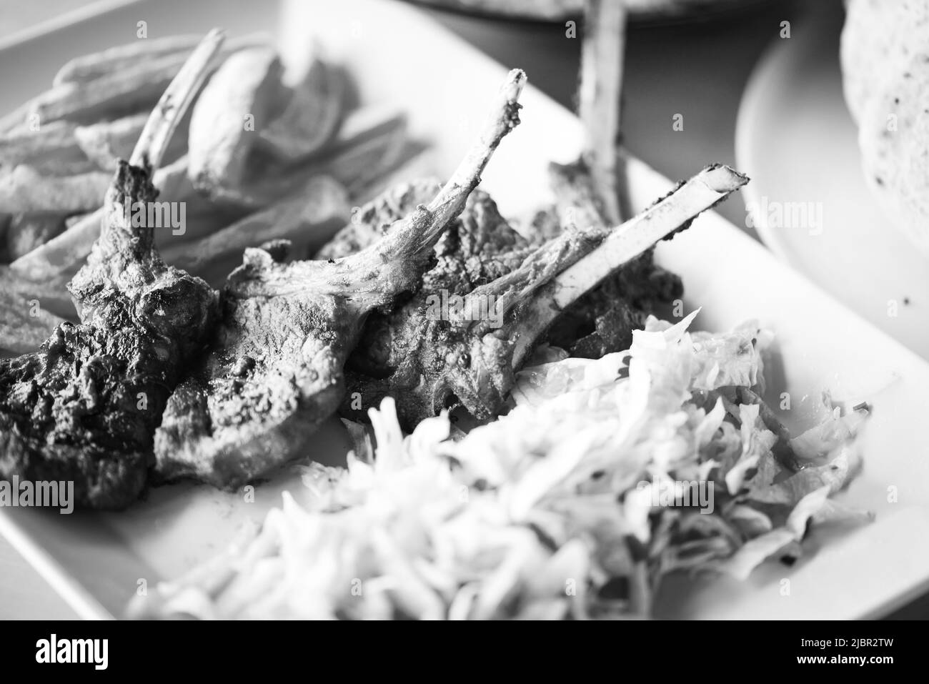 delicious grilled lamb chopsticks with french fries, pesto sauce & mix of lettuces Stock Photo