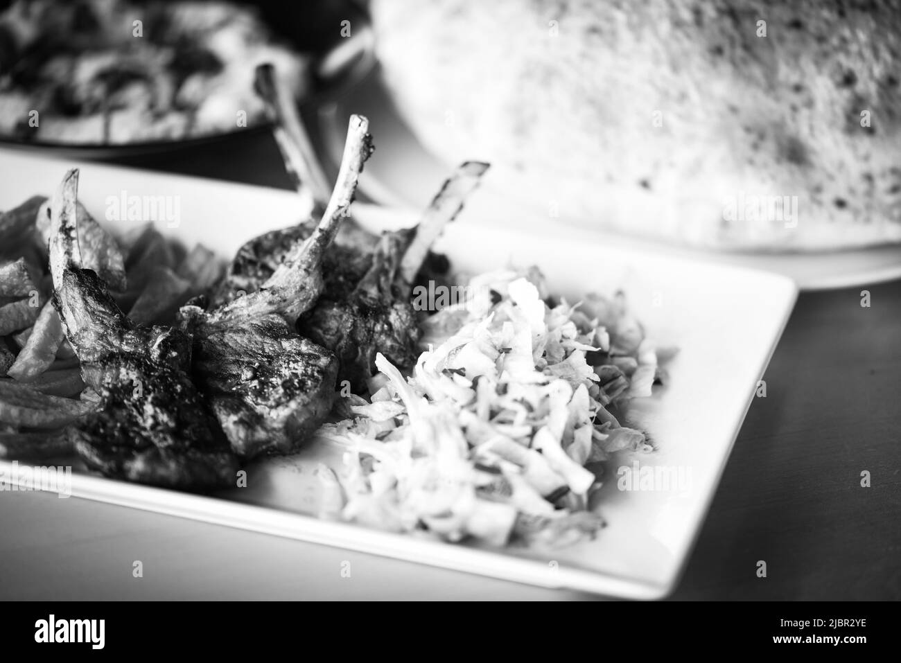 delicious grilled lamb chopsticks with french fries, pesto sauce & mix of lettuces Stock Photo