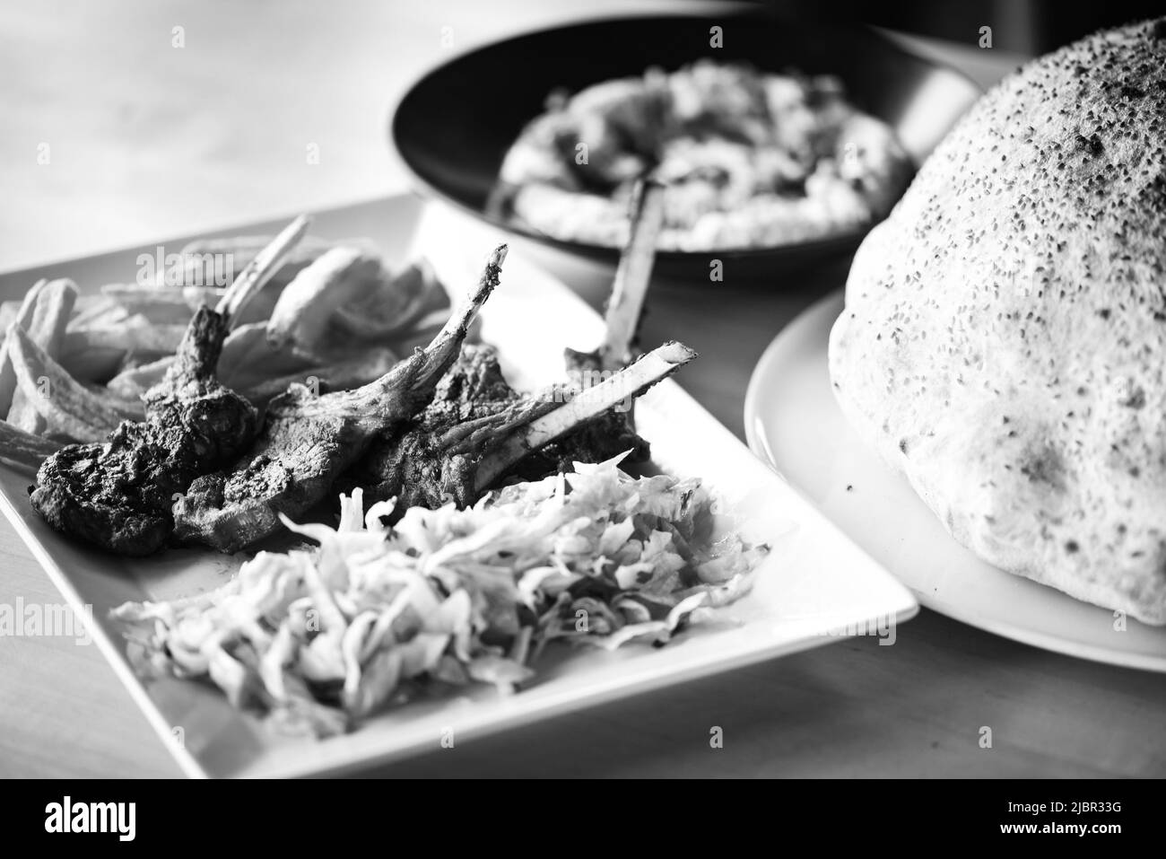 delicious grilled lamb chopsticks with french fries, pesto sauce & mix of lettuces Stock Photo