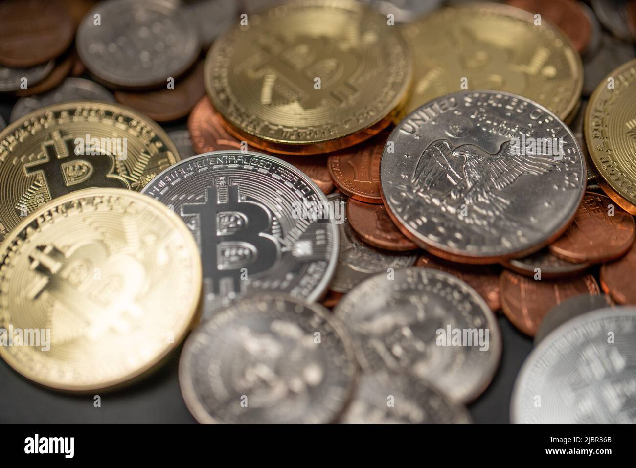 A pile of coins, US Dollar coins next to Crypto coins. Gold and Silver Bitcoins. Digital Currency concept. Trading USD with BTC Stock Photo