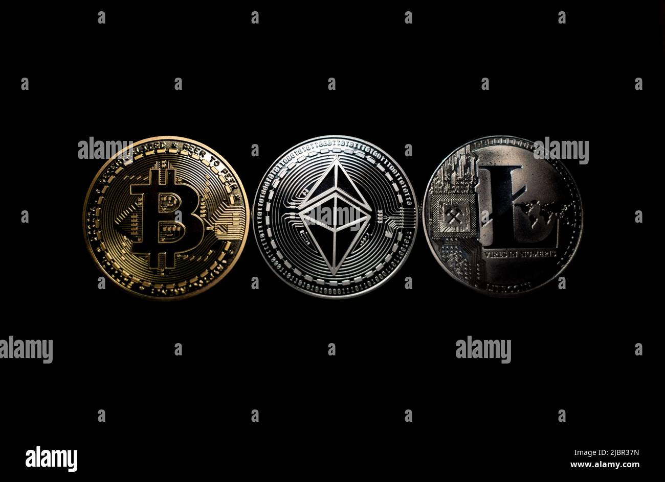 Bitcoin Ethereum and Litecoin on dark background. Gold and Silver shining Crypto coins. Blockchain technology. Digital commerce and payment systems. Stock Photo