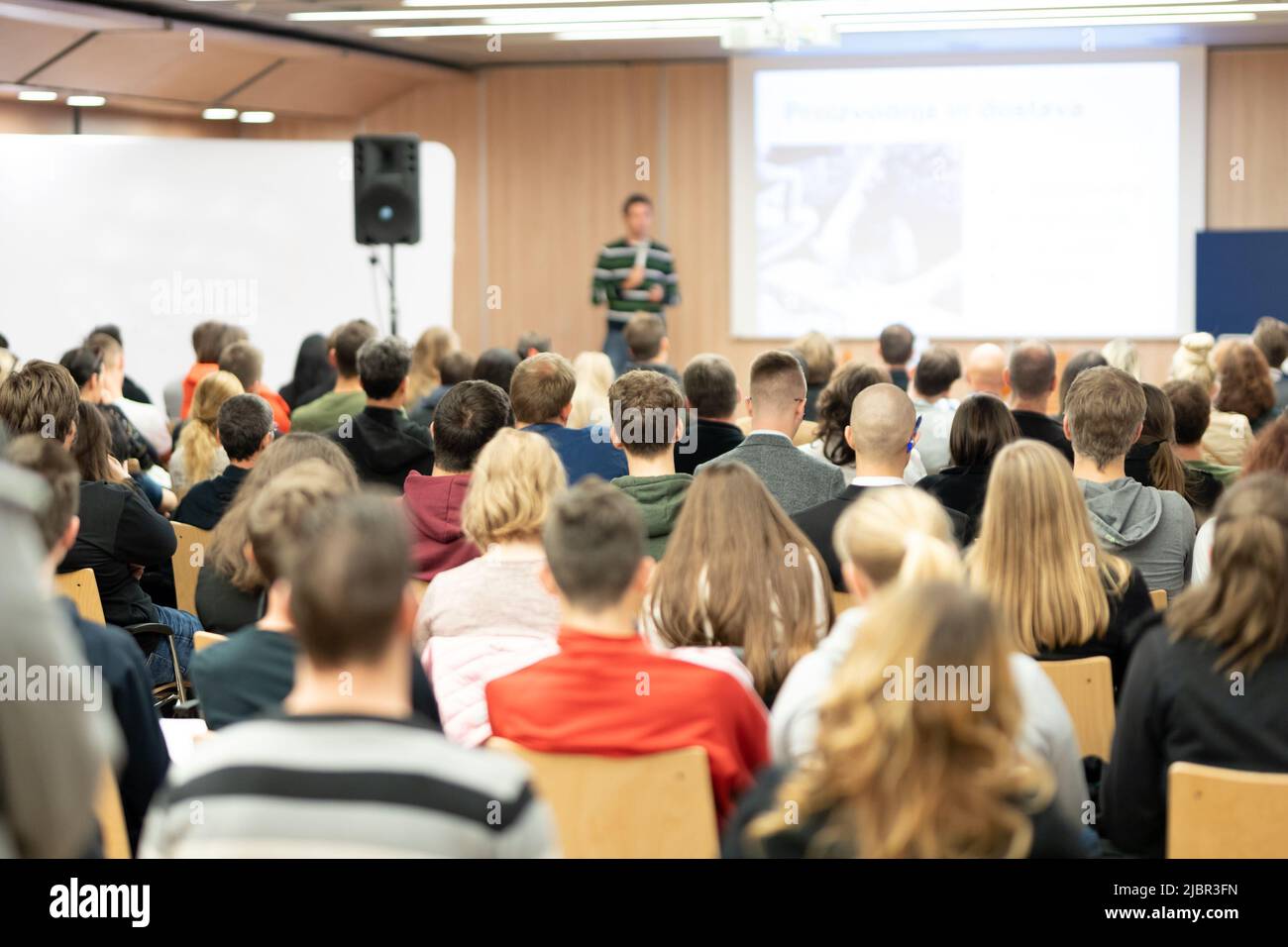 Speaker giving presentation in lecture hall at university Stock Photo