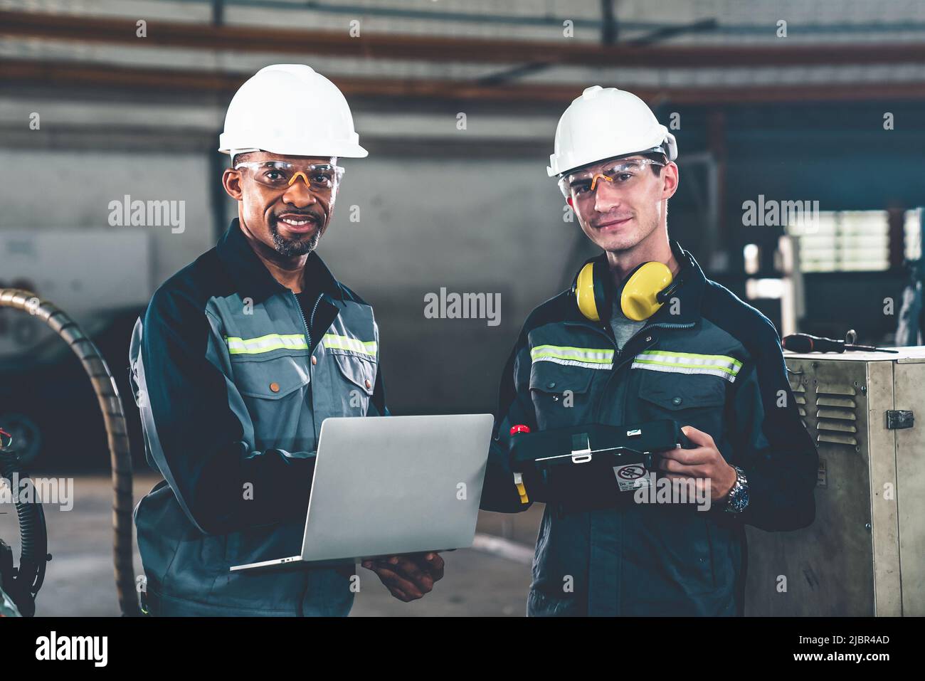 Two factory workers using adept machine equipment in a