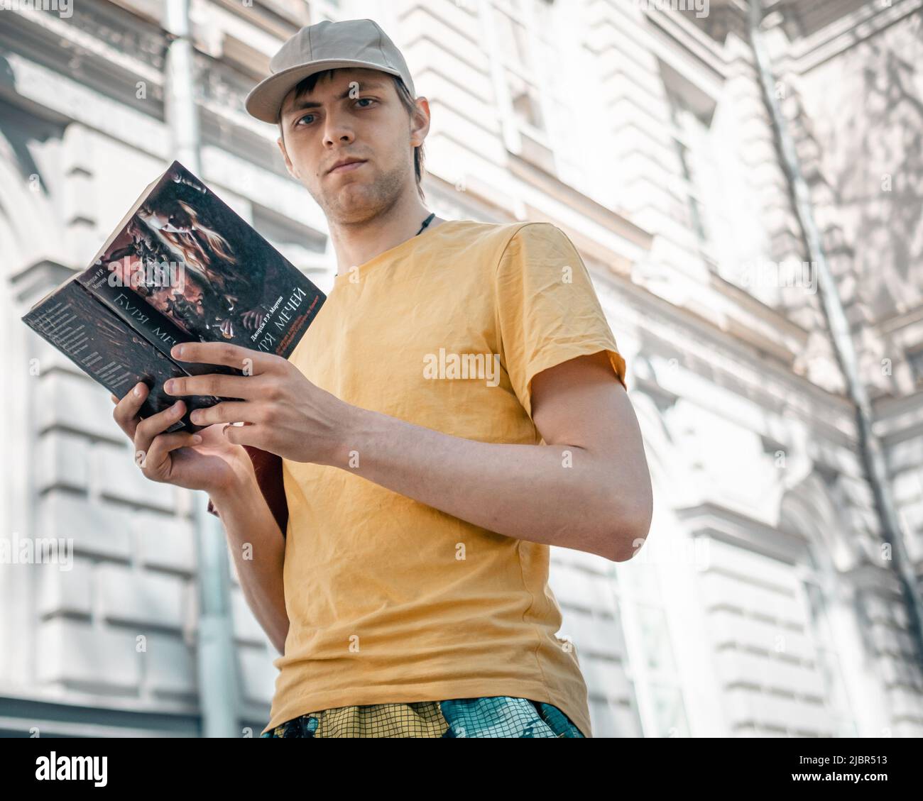 25 th of May, Russia, Tomsk, man with book on street reads on the go editorial Stock Photo