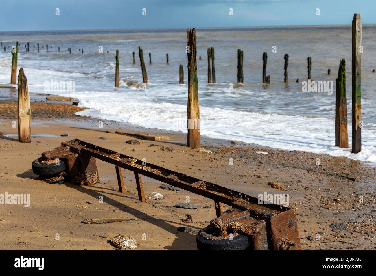 Steel trolly on the beach due to coastal erosion Stock Photo