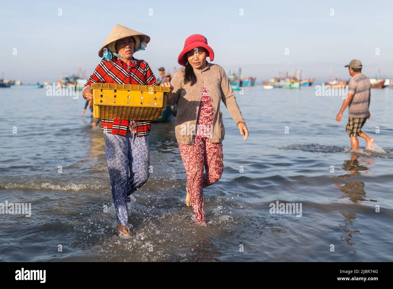 MUI NE, VIETNAM - November 9, 2016: Unidentified people unloading fishes in the morning at the beach in Mui Ne on November 9, 2016, Vietnam. Stock Photo