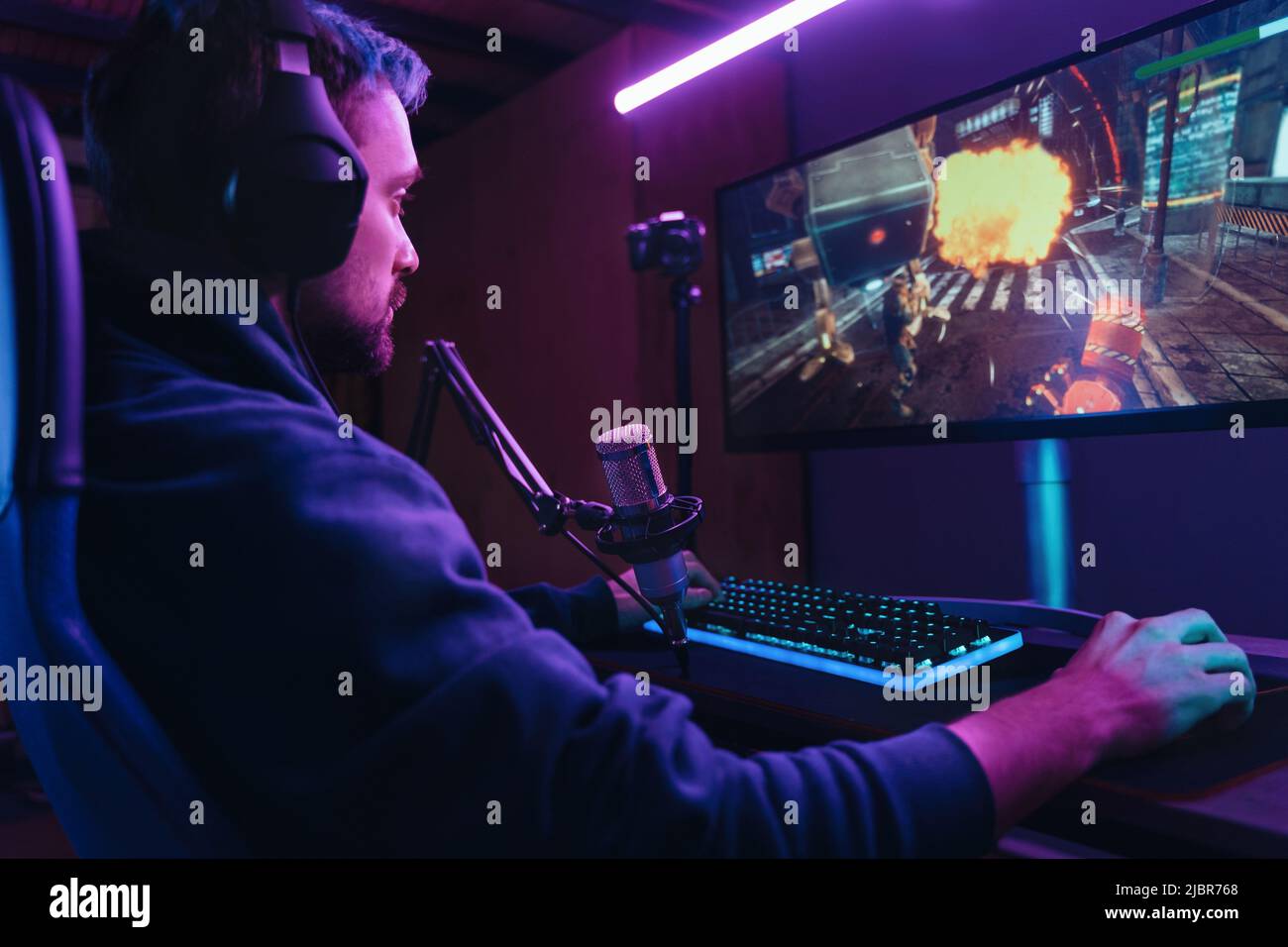 Streamer sitting on gaming chair and playing first person shooter