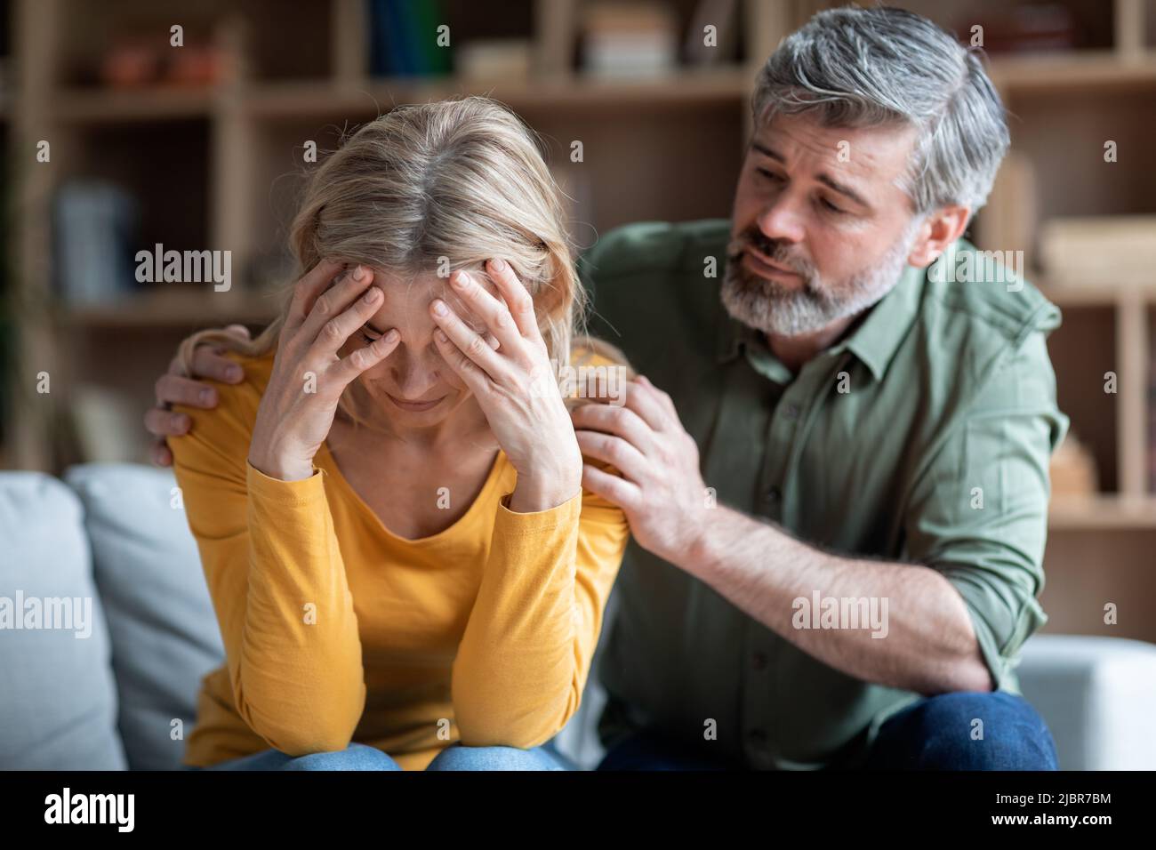 Midlife Crisis In Women. Caring Husband Comforting His Depressed Wife At Home Stock Photo