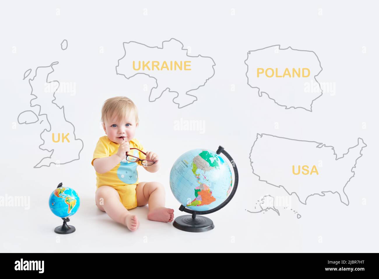 Ukrainian baby with globe. Earth Day. Travel and education. Early child development. Higher Education. Partner countries of Ukraine: UK, USA, Poland Stock Photo