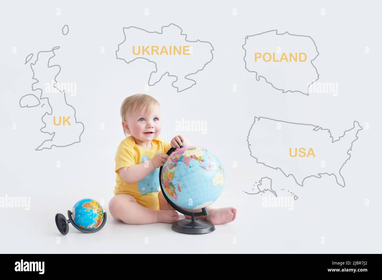 Ukrainian baby with globe. Earth Day. Travel and education. Early child development. Higher Education. Partner countries of Ukraine: UK, USA, Poland Stock Photo