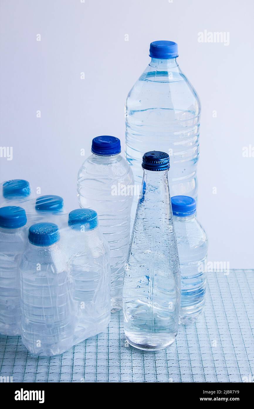 One group bottles of natural spring water on the glass surface.One of
