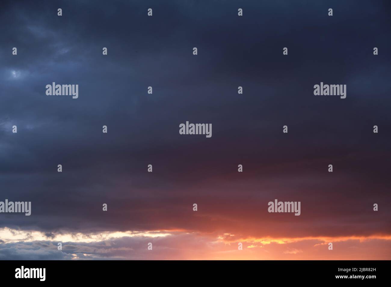 Thunderclouds with breaking rays sun at sunset Stock Photo