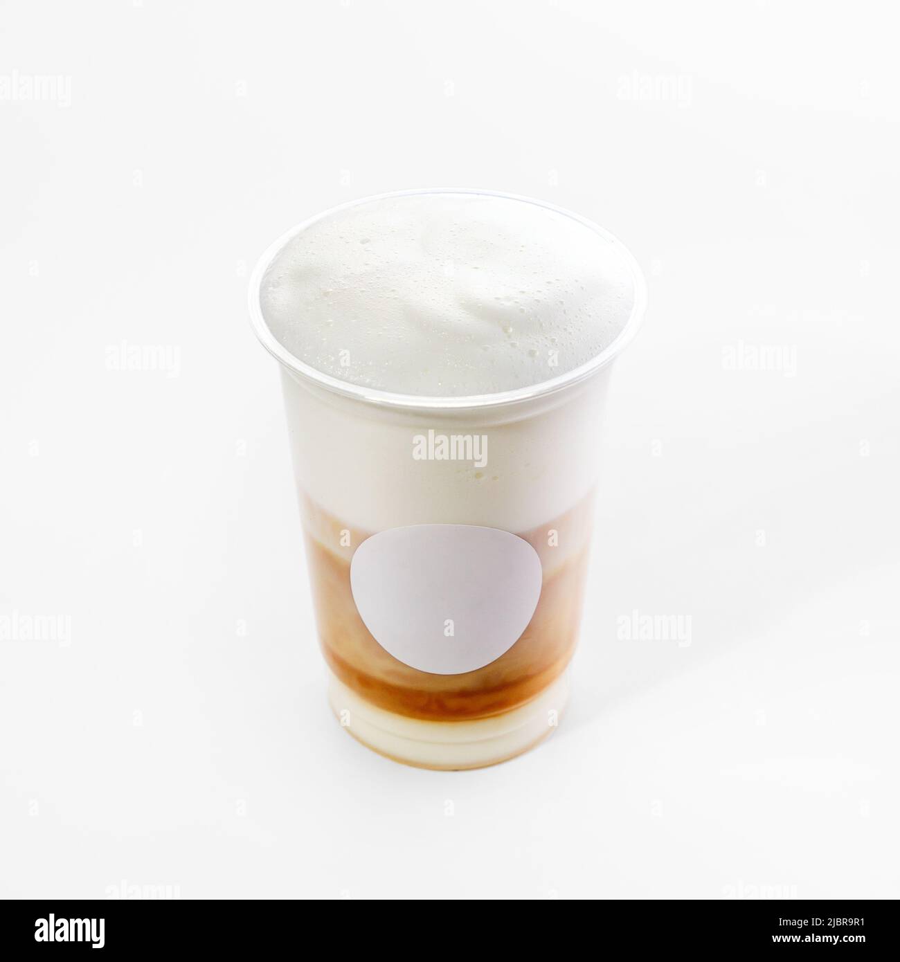 Plastic cup with hot cappuccino coffee with foam on a white background ...