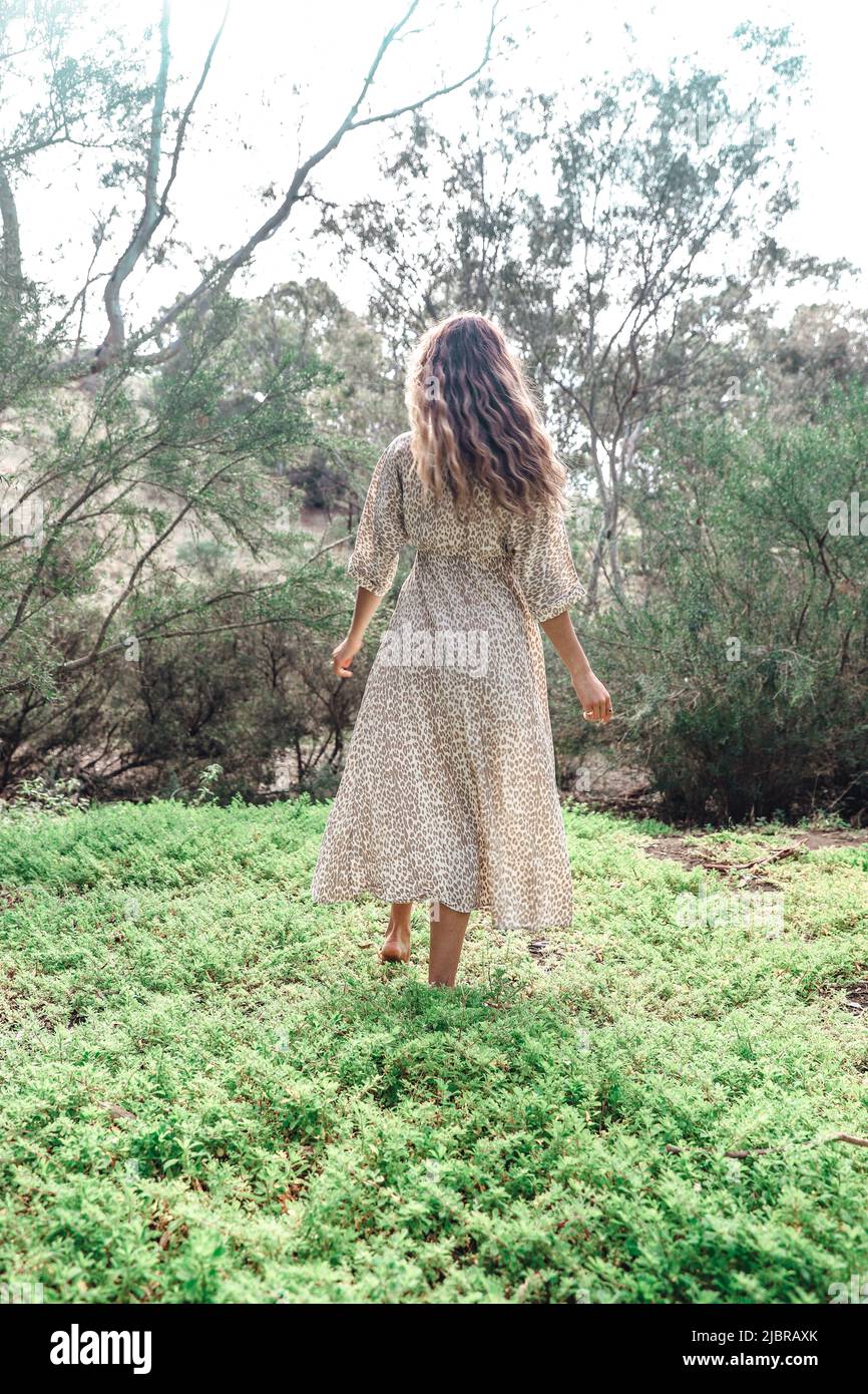 Bohemian girl wearing maxi dress in forest garden Stock Photo