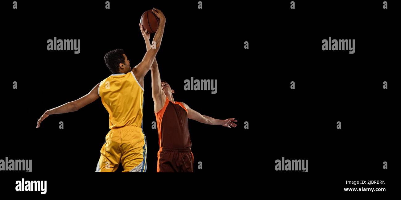 Portrait of two young men, professional basketball players in motion ...