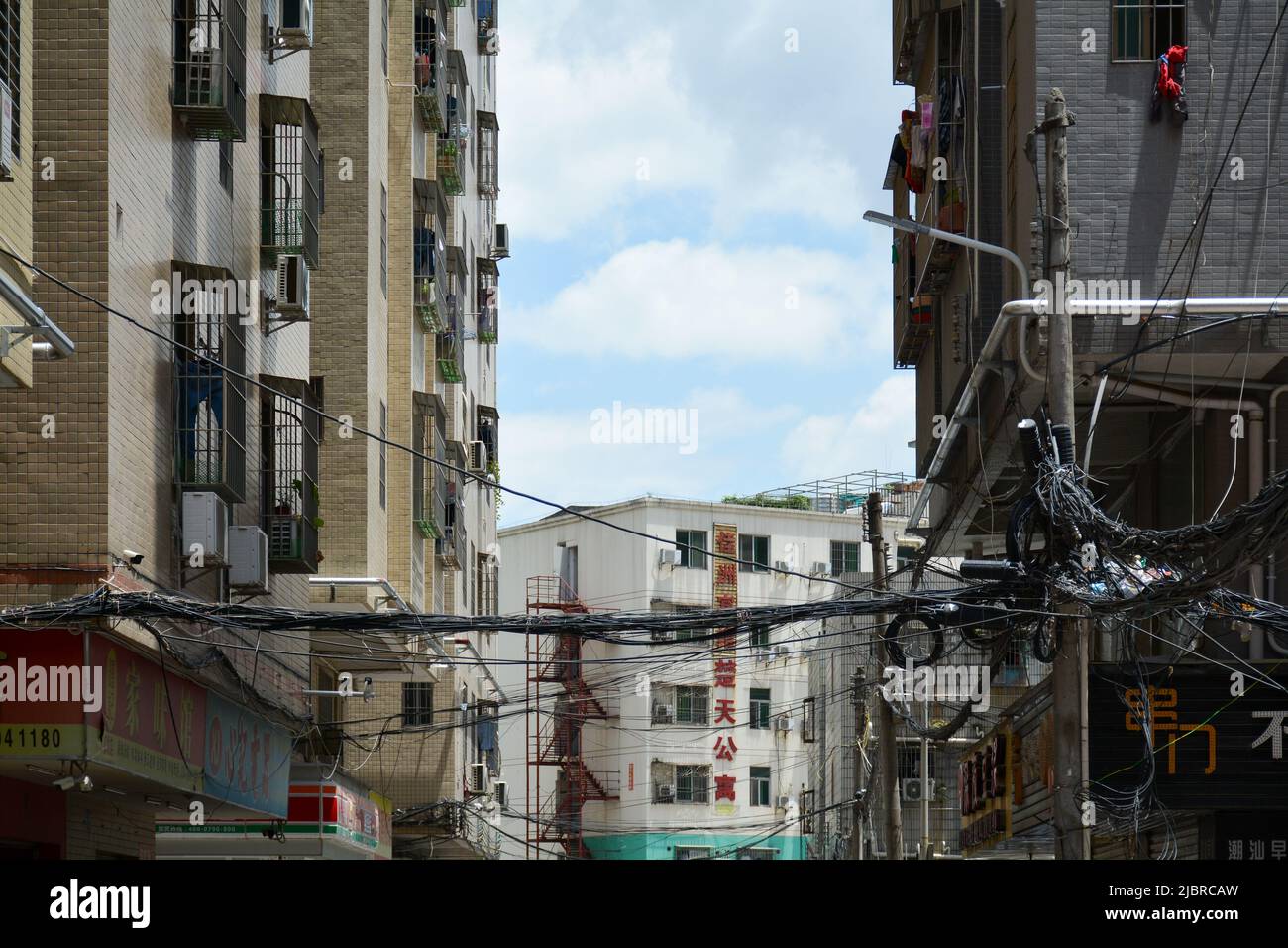 Crows nest of cables in a local community in the city of Shenzhen, China. A common sight as lines are just put up where they are needed. Stock Photo