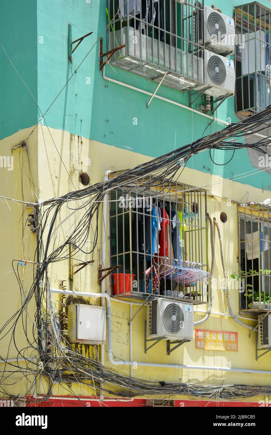 Crows nest of cables in a local community in the city of Shenzhen, China. A common sight as lines are just put up where they are needed. Stock Photo