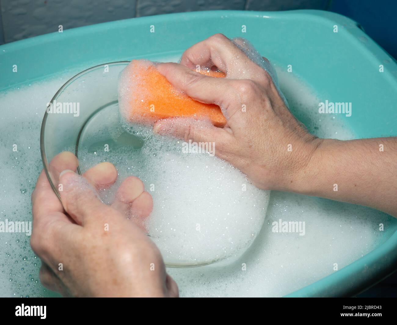 Washing dishes by hand. Washing the plate with a foam sponge. Lots of