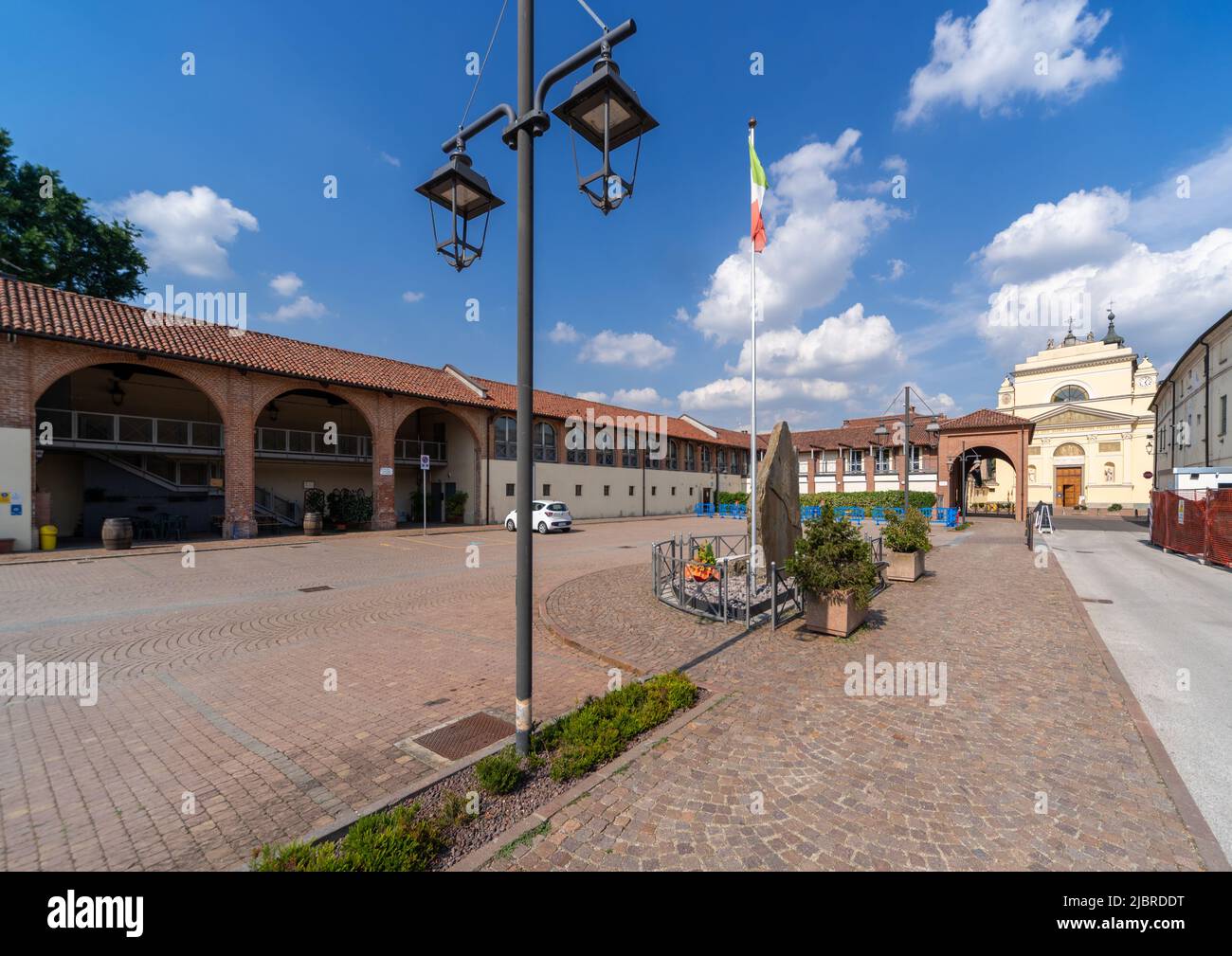 Casalgrasso, Cuneo, Italy - June 06, 2022: Piazzale Cavalieri di Vittorio Veneto with the parish church of San Giovanni in the background Stock Photo