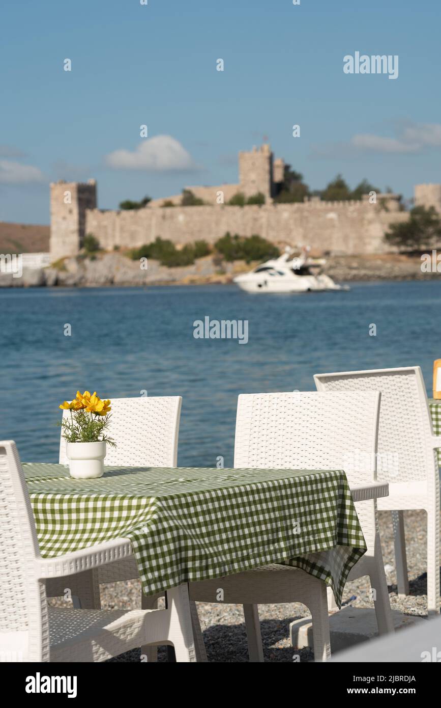 Bodrum, Mugla, Turkey. April 21st 2022 Pretty seaside cafe restaurant tables with table cloths and flowers overlooking Bodrum harbour on the western A Stock Photo