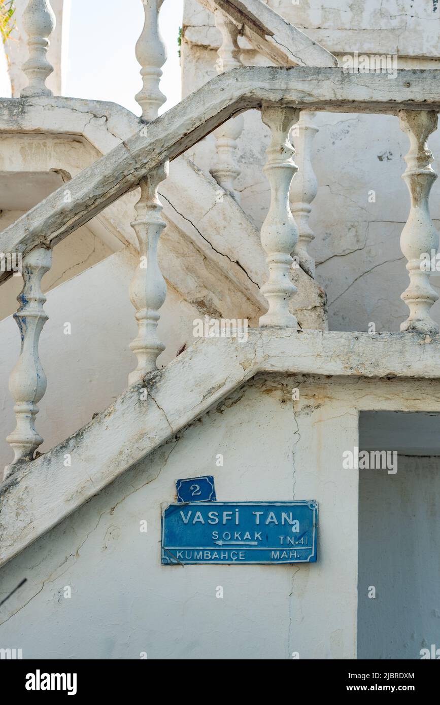 Bodrum, Mugla,Turkey. April 23rd 2022 Blue street sign for Vasfi Tan Sokak and traditional white painted stone balustrade in the alleys and side stree Stock Photo