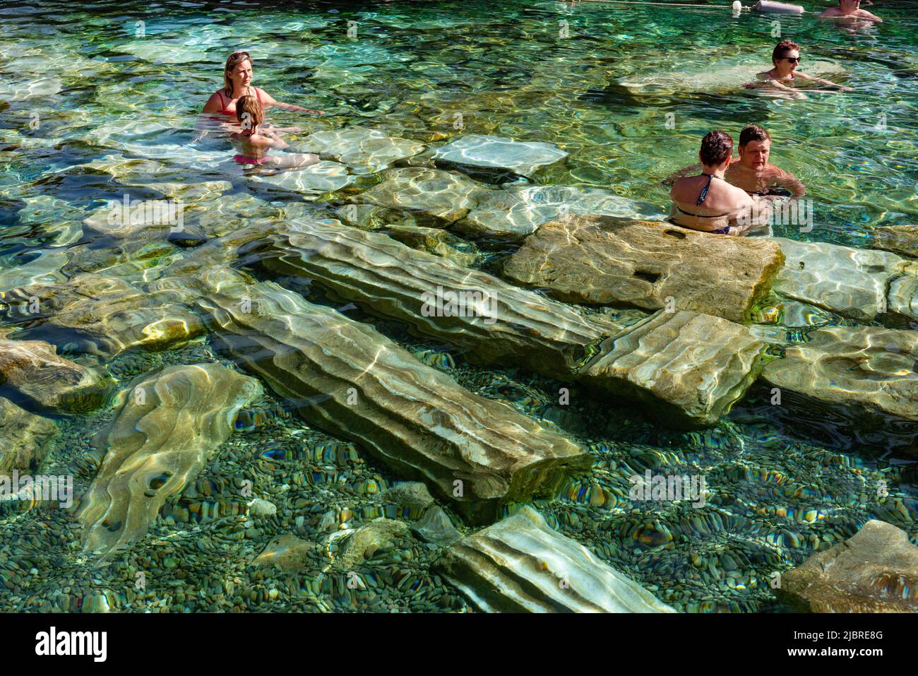 Pamukkale, Turkey, April 25th 2020 Foreign tourists enjoys the healing properties of thermal waters among fallen Roman columns in Cleopatra’s Antique Stock Photo