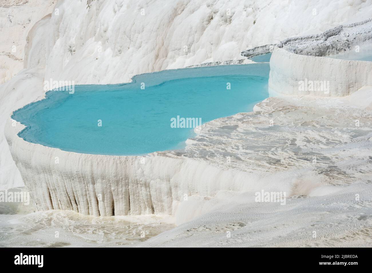 Beautiful aqua blue pools of natural mineral rich spring water with many healing properties in beautiful Pamukkale , the cotton castle of western Turk Stock Photo