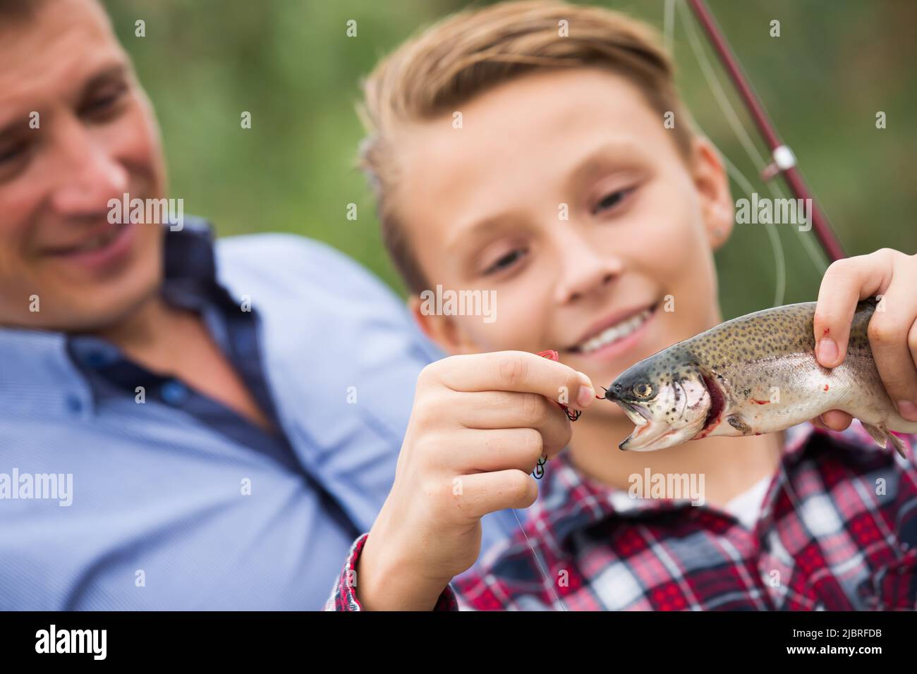 Smiling teenage boy catching on hook fish Stock Photo